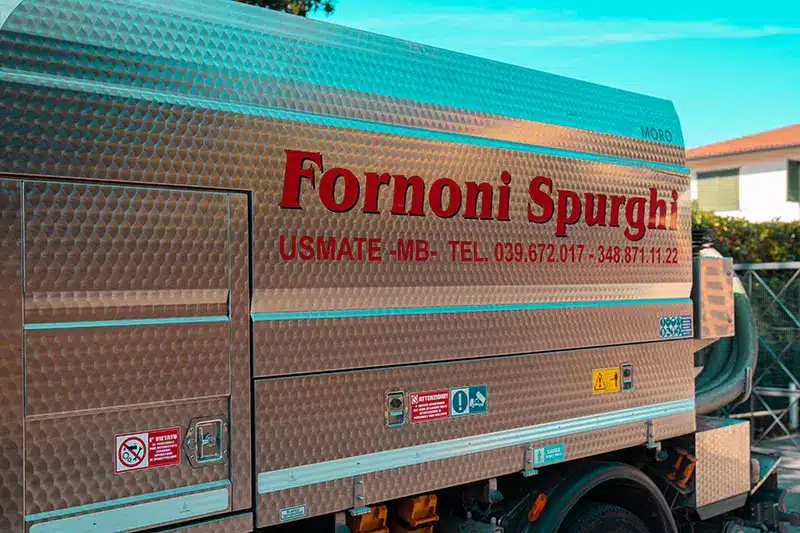 Primo piano camion di Fornoni Spurghi con sede e numero di telefono, attiva in provincia di Monza Brianza e Milano.